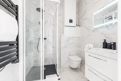 a white bathroom with a shower and a toilet at 7 FOCH 202 - Studio contemporain en plein coeur de Nice - climatisation in Nice