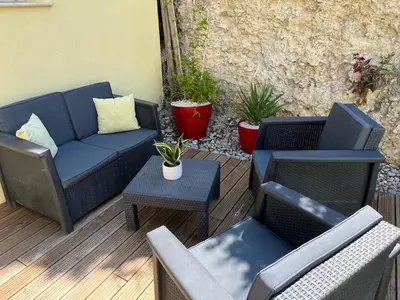a patio with two chairs and a couch and a table at Petite maison, cosy, sur les collines niçoises in Nice