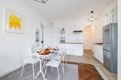 a white kitchen with a white table and chairs at MY CASA - MEDECIN 43 - Superb Bright City Center Apartment in Nice