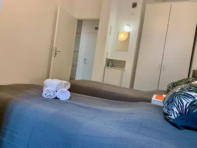 a room with a bed with two rolled towels on it at ApartHotel Riviera - MAISON DU GRAND SUD - Confortable petit 3 pièces - Promenade des Anglais in Nice