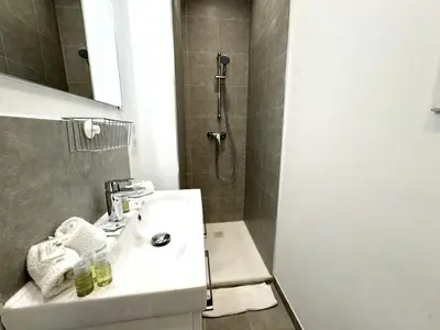 a bathroom with a sink and a shower at ApartHotel Riviera - MAISON DU GRAND SUD - Confortable petit 3 pièces - Promenade des Anglais in Nice
