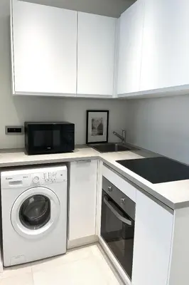 a kitchen with a washing machine and a microwave at 1 bedroom Brand new flat in the heart of Nice quartier des Musiciens in Nice