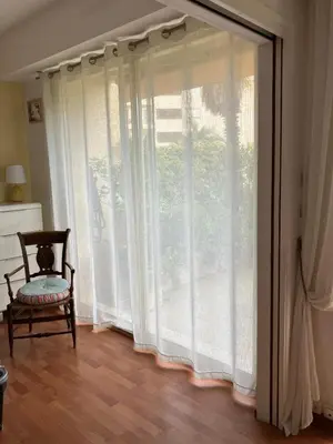 a room with a large window with a chair next to it at Beaulieu in Beaulieu-sur-Mer