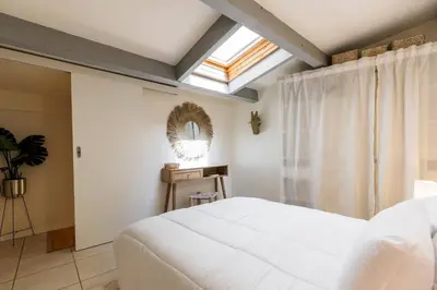 a bedroom with a white bed and a skylight at 3 pièces au cœur du carré d'or in Nice