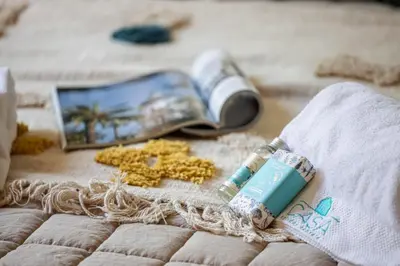 a book and a bottle of soap and flowers on a blanket at MY CASA - GUIDONI - Superb City Center Suite Apartment in Nice