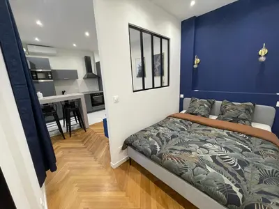 a bedroom with a blue accent wall and a bed at Appart Cosy, Proche Gare in Nice