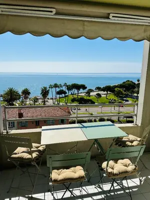 a balcony with a table and chairs and a view of the ocean at Cote d’Azur Charm, Studio Apartment with panoramic seaview in Nice in Nice