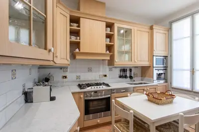 a kitchen with wooden cabinets and a white table at #15 Sea front Villa AC stunning view for 6 pers wifi in Nice