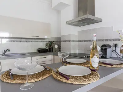 a kitchen with plates and wine glasses on a counter at Apartment Les Balcons d'Eze-3 by Interhome in Èze