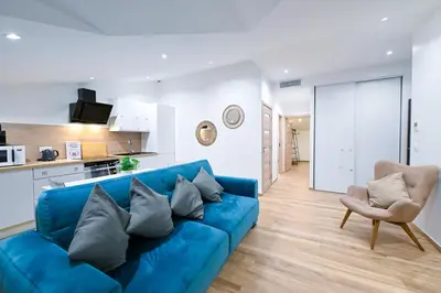 a living room with a blue couch and a chair at Trois pièces cozy n14 in Nice