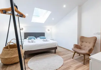 a bedroom with a bed and a chair at Trois pièces cozy n14 in Nice