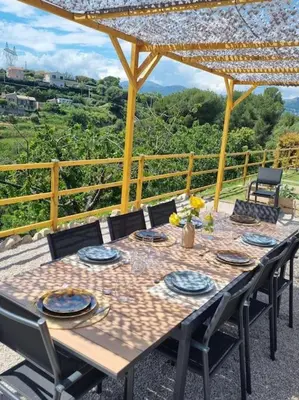 a wooden table with chairs and a tableasteryasteryasteryasteryasteryasteryasteryastery at Superbe bas de Villa au calme in Cagnes-sur-Mer