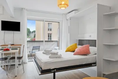 a bedroom with a bed and a desk and a tv at Le Mistral in Nice