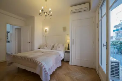 a bedroom with a bed and a chandelier at Luxury apartment on Promenade des Anglais in Nice in Nice