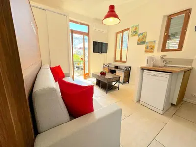 a table with a bouquet of red flowers on it at ⁂ Studio cosy 3 min de la plage terrasse clim in Nice