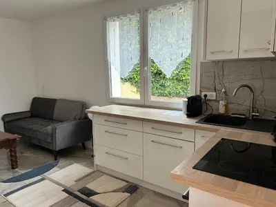 a kitchen with white cabinets and a stove top oven at Duplex Oliveraie piscine au sel marin et parking in Nice