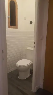 a bathroom with a white toilet and a mirror at chez steph in La Trinité