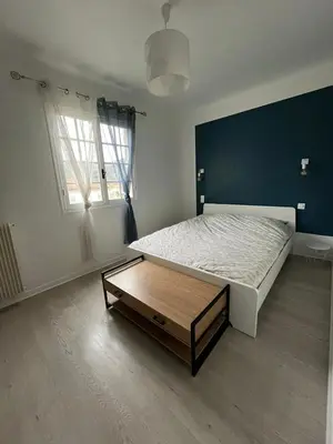 a bedroom with a bed and a table in it at chez steph in La Trinité
