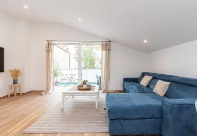 a living room with a blue couch and a table at Studio cozy avec terrasse n12 in Nice