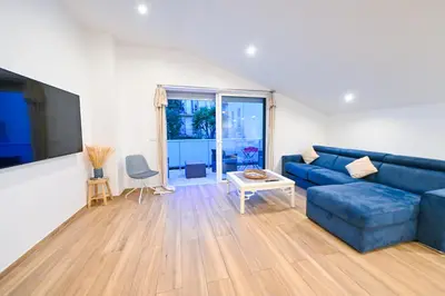 a living room with a blue couch and a table at Studio cozy avec terrasse n12 in Nice