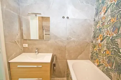 a bathroom with a sink and a tub and a mirror at Luxury Sea Front Condo Milord in Nice