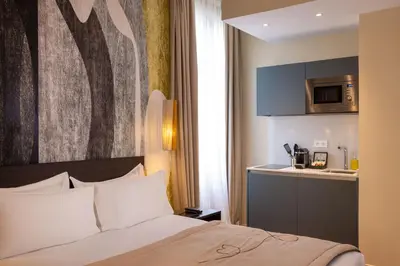 a hotel room with a bed and a kitchen at Palais Ségurane Boutique Hôtel in Nice