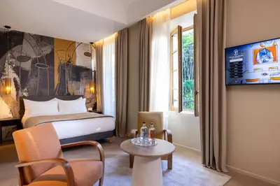 a hotel room with a bed and a table at Palais Ségurane Boutique Hôtel in Nice