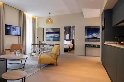 a living room with a table and chairs and a bedroom at Palais Ségurane Boutique Hôtel in Nice