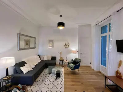 a living room with a couch and a table at Les Orangers - 3 Pièces avec terrasse arborée in Nice
