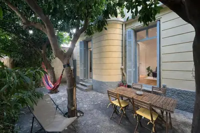 a wooden table and chairs next to a tree at Les Orangers - 3 Pièces avec terrasse arborée in Nice