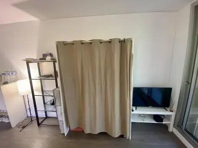 a curtain in the corner of a room with a television at Nice ouest-Cosy Studio, Clim Wifi in Nice