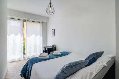 a white bedroom with a large bed and a window at Maison Bianchi - Downtown Alsace Lorraine in Nice