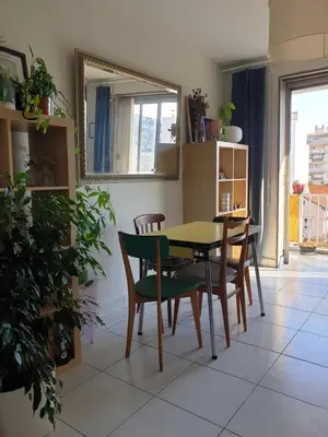 a dining room with a table and chairs and a mirror at Bel appartement lumineux T3 Terrasse in Nice