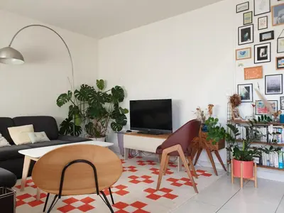a living room with a couch and a tv at Bel appartement lumineux T3 Terrasse in Nice