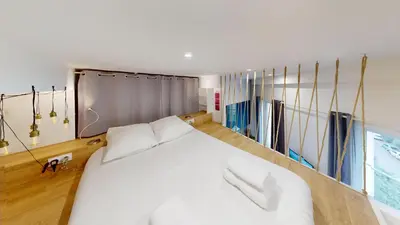 a bedroom with a large white bed and curtains at Joli studio centre-ville Nice proche de la gare in Nice
