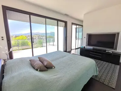 a bedroom with a bed with two pillows and a television at Villa Les Oliviers by Interhome in Nice