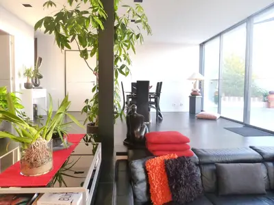 a living room with a black leather couch with red pillows at Villa Les Oliviers by Interhome in Nice