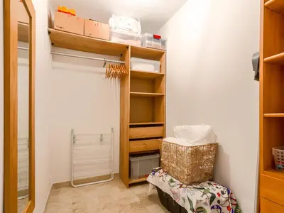 a room with a closet with a chair and shelves at Apartment Les Balcons de Battisti by Interhome in Nice