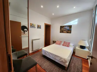 a small bedroom with a bed and a chair at Villa Bethanie in Villefranche-sur-Mer
