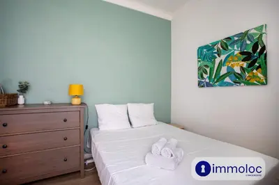 a bedroom with a bed and a dresser with towels on it at Apartment with 2 bedrooms Quartier Libération in Nice