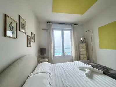 a bedroom with a white bed with a window at VUE mer 02 chambres 45M et parking in Nice