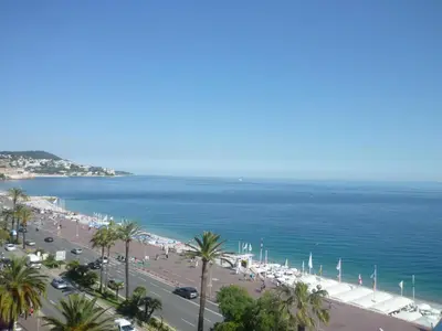 a balcony with a table and chairs and a view of the ocean at VUE mer 02 chambres 45M et parking in Nice