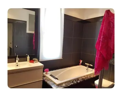 a bathroom with a white tub and a pink towel at Villa Nice in Nice