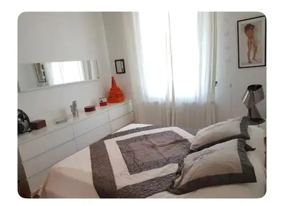 a white bedroom with a bed and a mirror at Villa Nice in Nice