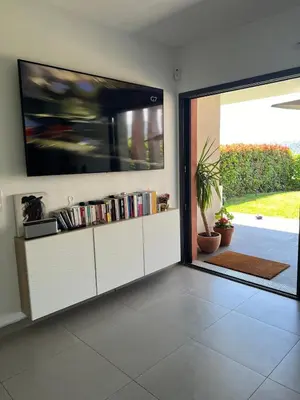 a living room with a tv and a sliding glass door at Joli 3 pièces ensoleillé sur les hauteurs de Nice in Nice