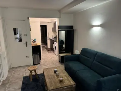 a living room with a blue couch and a table at Studio à Nice - 10 min de la plage in Nice
