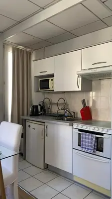 a kitchen with white cabinets and a stove top oven at 1 bedroom flat in the best street Nice in Nice