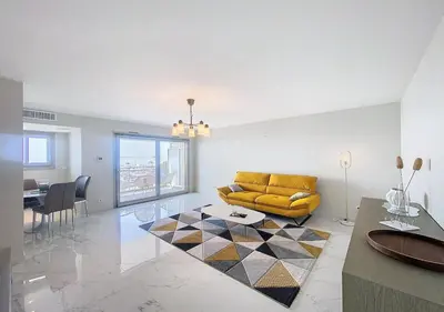 a living room with a yellow couch and a table at Horizon bleu vue mer dernier étage clim in Saint-Laurent-du-Var