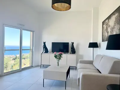 a living room with a couch and a tv at Panoramic Sea View Appartment Blue Pearl in Nice