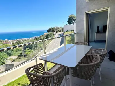a white table and chairs on a balcony with the ocean at Panoramic Sea View Appartment Blue Pearl in Nice